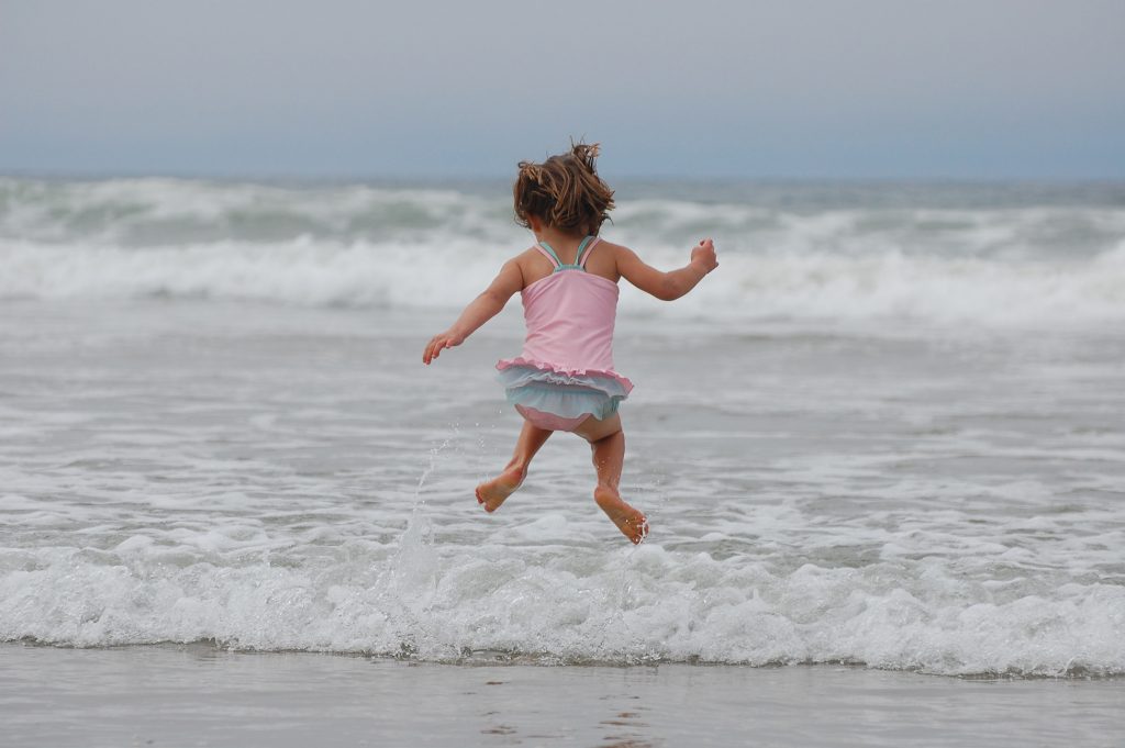 Ett barn hoppar i vattenbrynet